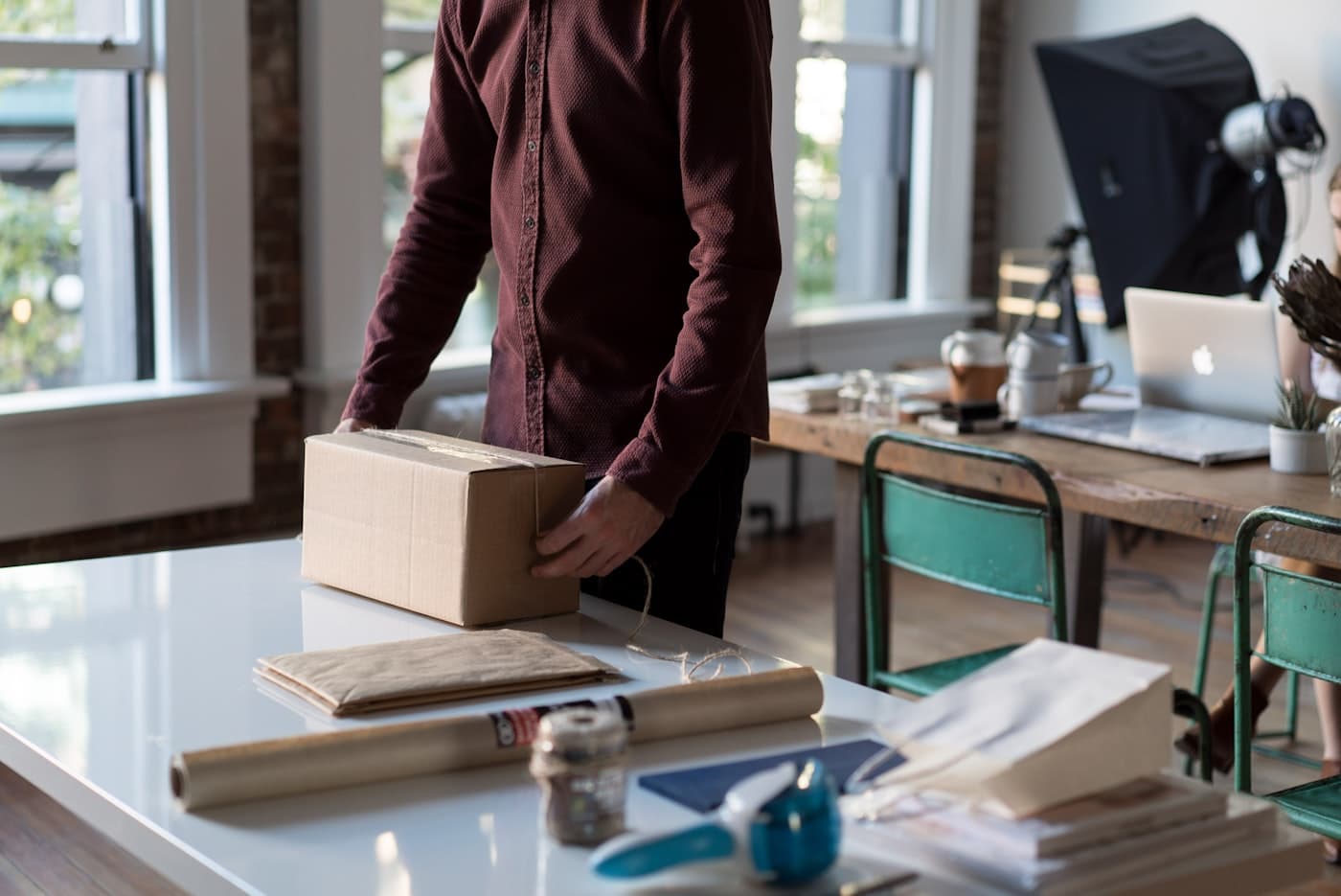 Persona empaquetando un pedido de su tienda online en un escritorio